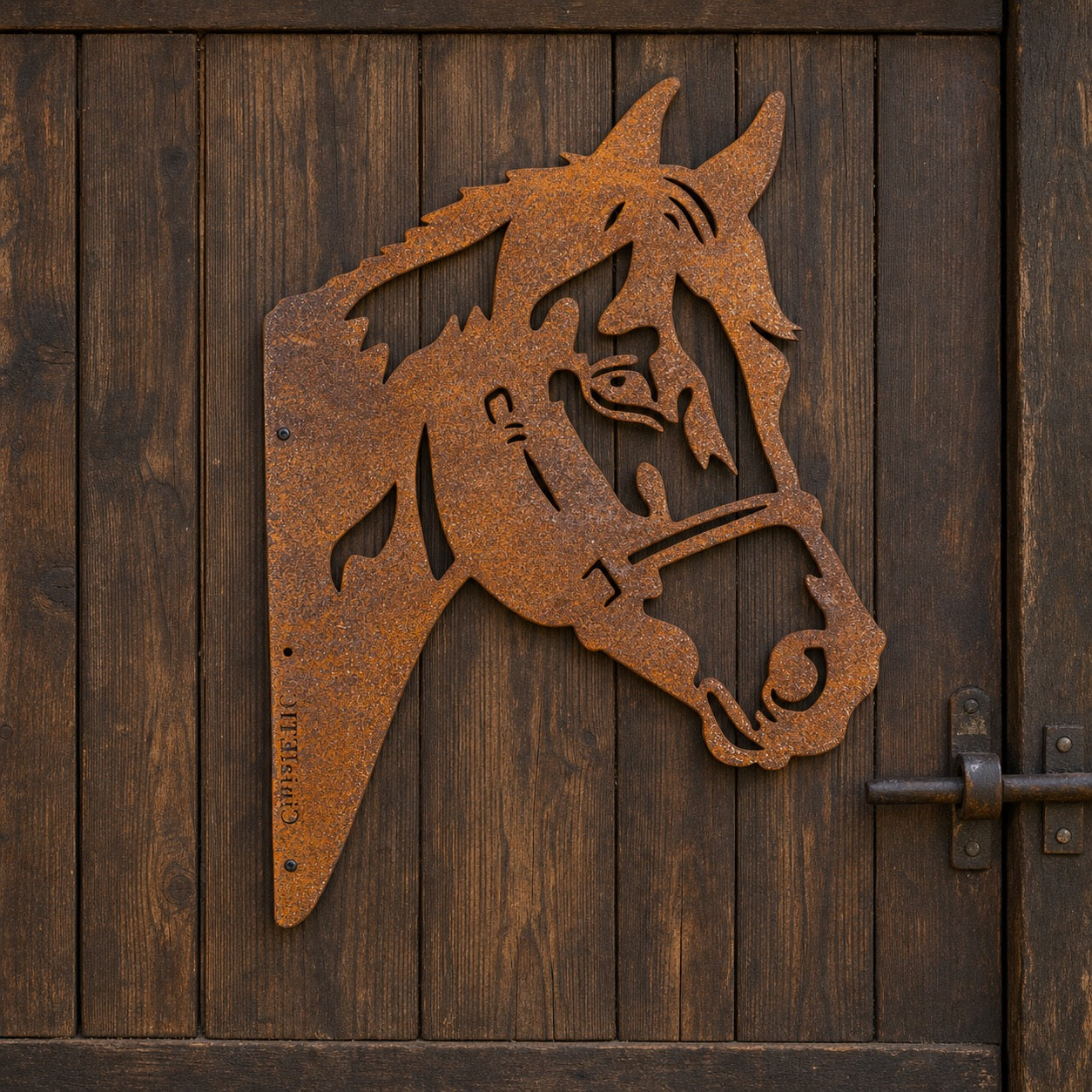 Silhouette tête de cheval en métal rouillé fixée sur une porte en bois sombre, motif décoratif au style rustique.