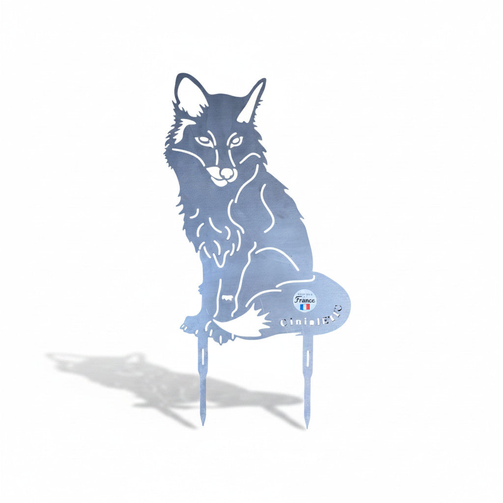 Silhouette renard assis en métal, découpe bleue, avec pancarte et suspensions au bas, ombre portée sur le sol.